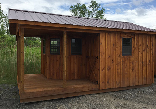 barn style wood board and batten shed with wraparound porch