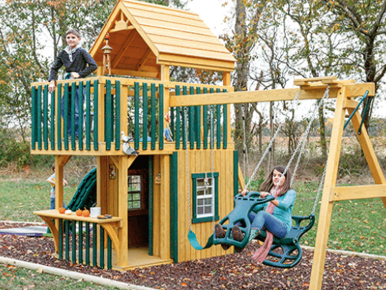 kids playing on wooden swingset with slide